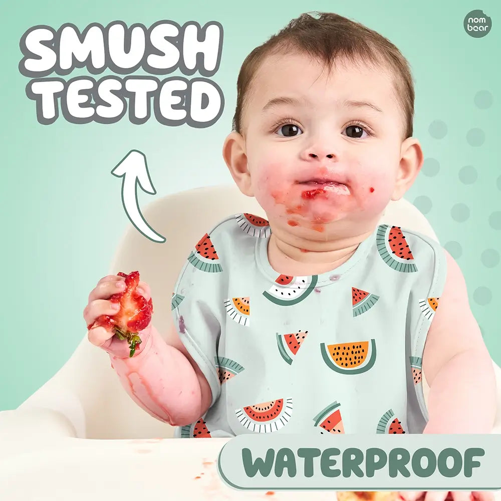 Baby Wearing a Bib with Blue Melons Pattern, Smushing a Strawberry. Smush Tested. Waterproof.