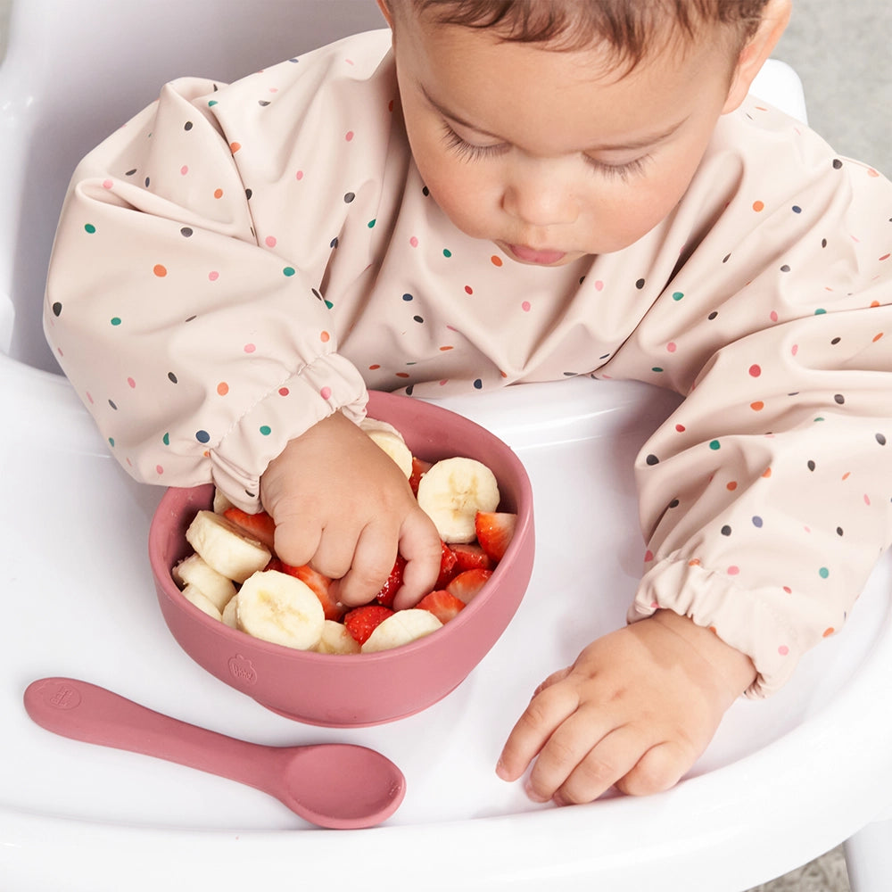 Baby Tucks into a Bowl of Strawberries and Bananas in his Nombear Baby Feeding Bib, Photo Shot from Above