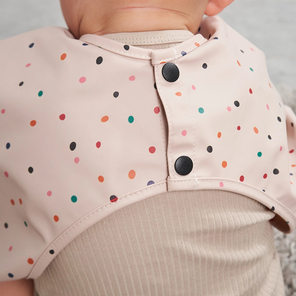 Close Up of a Pink Weaning Bib with Snap on Buttons at the Back so the Bib Can't be Removed by Baby