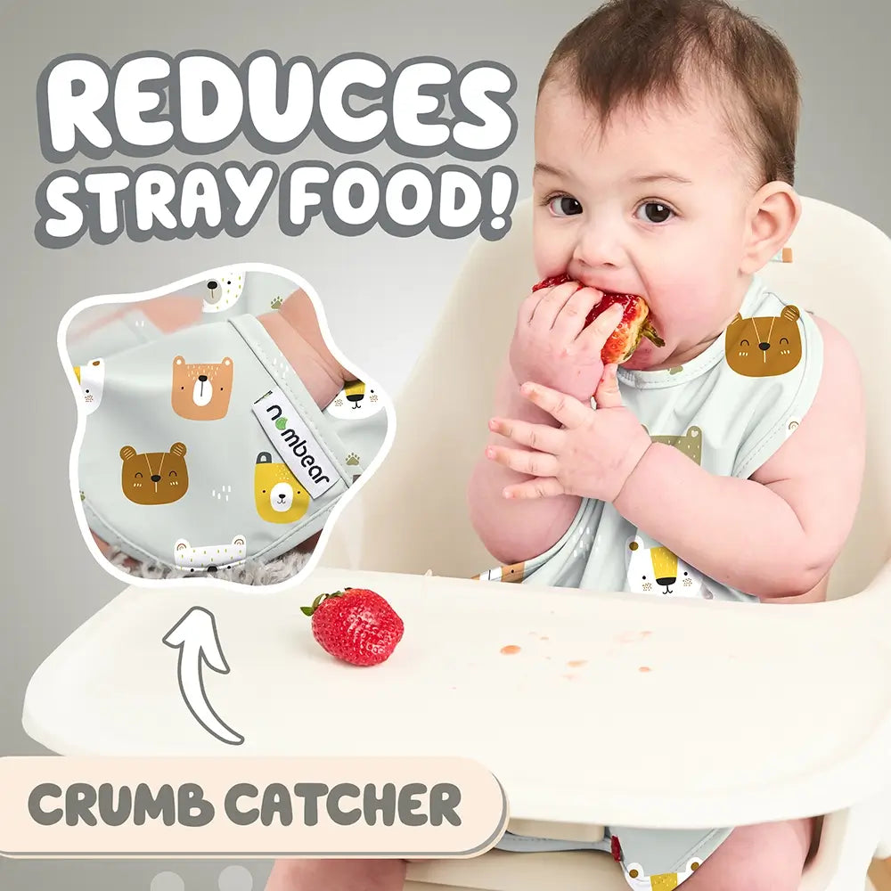 Baby Eating a Strawberry Wearing a Grey Bib. Reduces Stray Food! With Crumb Catcher.