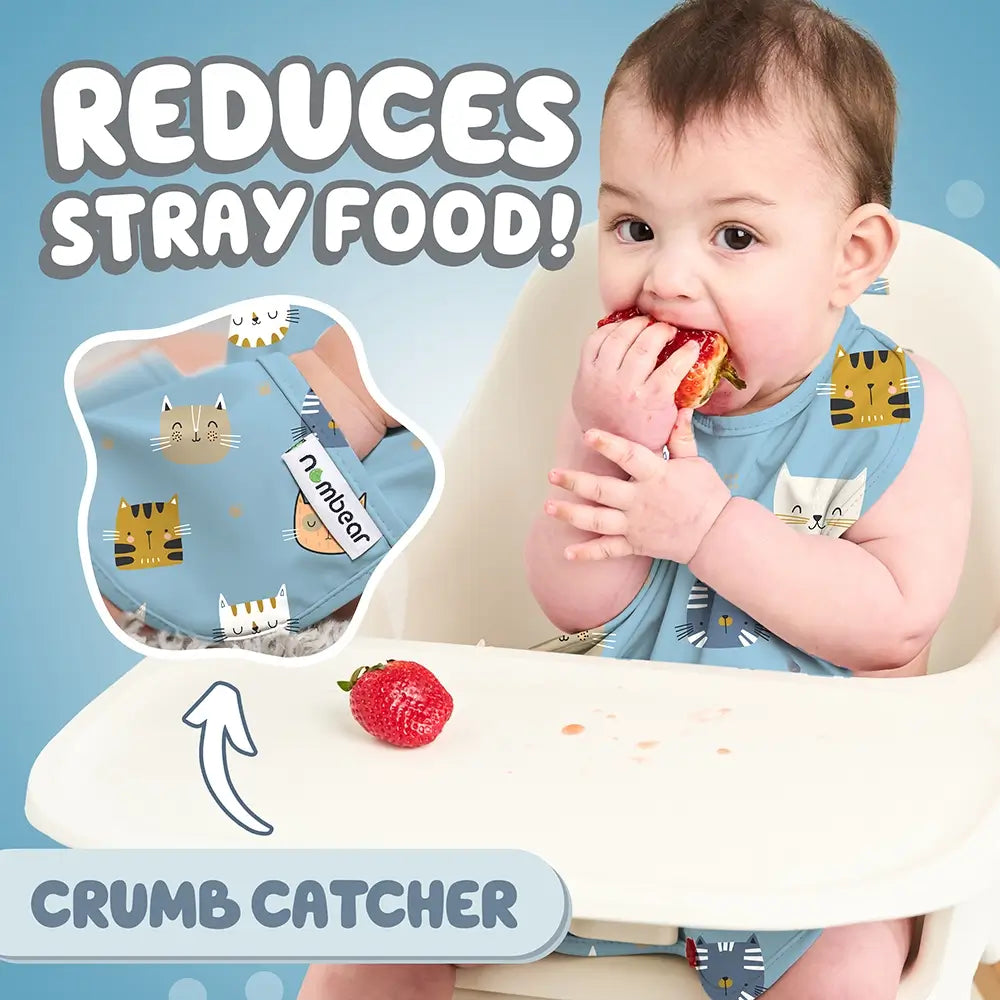 Baby Eating a Strawberry Wearing a Blue Bib. Reduces Stray Food! With Crumb Catcher.