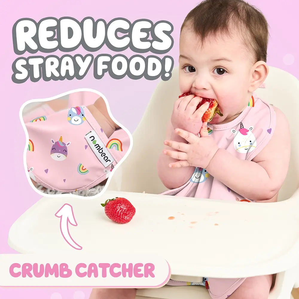 Baby Eating a Strawberry Wearing a Unicorn Print Bib. Reduces Stray Food! With Crumb Catcher.
