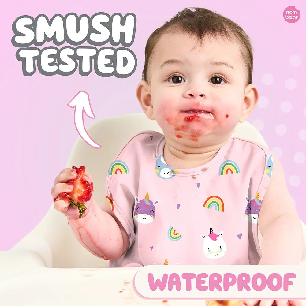 Baby Wearing a Bib with Unicorns Pattern, Smushing a Strawberry. Smush Tested. Waterproof.