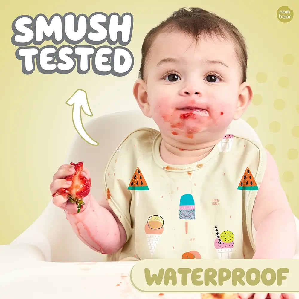 Baby Wearing a Bib with Ice Cream Pattern, Smushing a Strawberry. Smush Tested. Waterproof.
